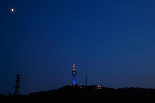 a tv tower lit up in the dark at night at Oriens Hotel & Residences Myeongdong in Seoul
