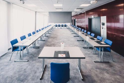 a conference room with tables and chairs and a chalkboard at elaya hotel stuttgart ludwigsburg ehemals Abacco by Rilano in Korntal-Münchingen