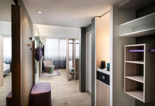 a small room with a hallway with a bedroom at elaya hotel stuttgart ludwigsburg ehemals Abacco by Rilano in Korntal-Münchingen