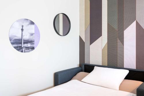 a bedroom with a bed and a mirror at elaya hotel stuttgart ludwigsburg ehemals Abacco by Rilano in Korntal-Münchingen