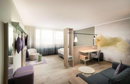 a living room with a couch and a table at elaya hotel stuttgart ludwigsburg ehemals Abacco by Rilano in Korntal-Münchingen