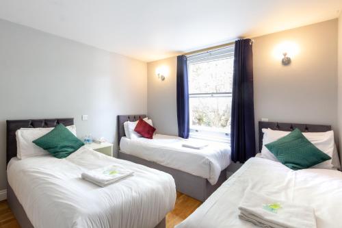 a room with two beds and a window at Coronation Hotel in London