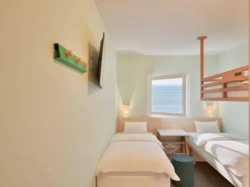 ニースにあるGreet Hotel Nice Aéroport Promenade des Anglaisのベッド2台と窓のある病室です。