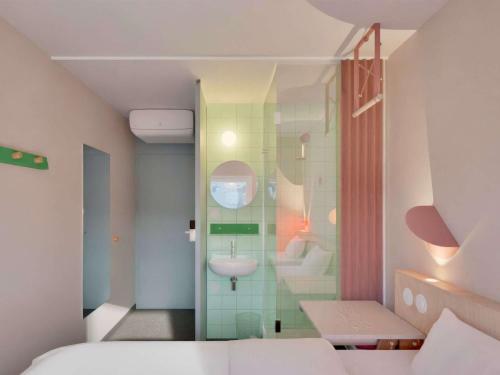 Cette chambre comprend une salle de bains pourvue d'un lavabo et d'un miroir. dans l'établissement Greet Hotel Nice Aéroport Promenade des Anglais, à Nice
