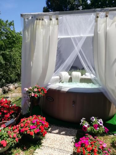 a soak in a hot tub in a garden with flowers at Il cielo in una stanza in Itri