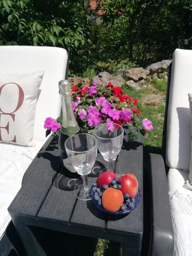 a table with wine glasses and fruit and flowers at Il cielo in una stanza in Itri