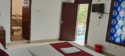 a room with a bed and a bathroom with a window at Bandipur Resort Khan's Gufa in Gundlupet