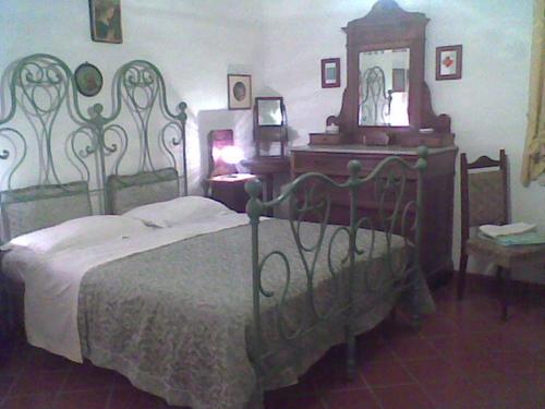 a bedroom with a bed and a dresser and a clock at Bed&Breakfast Giardino Agritourist in Controguerra