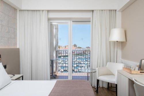 a hotel room with a bed and a window with a view at AP Eva Senses in Faro
