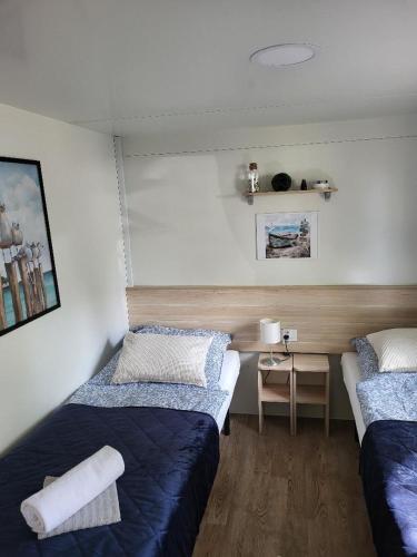a room with two beds and a desk in it at Mobilheim ANDREA wunderschöne Ferienwohnung direkt am Meer in Jezera