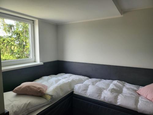 una camera da letto con un letto con cuscini e una finestra di City Lounge an der Feuerwache mit Außenbereich mit Klimaanlage a Wolmirstedt