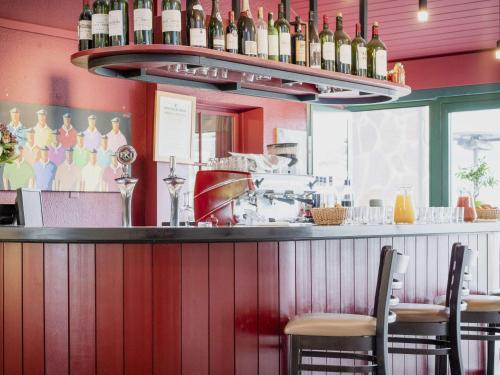 a bar with a bunch of bottles of wine at Hotel Donibane Saint-Jean-de-Luz in Saint-Jean-de-Luz