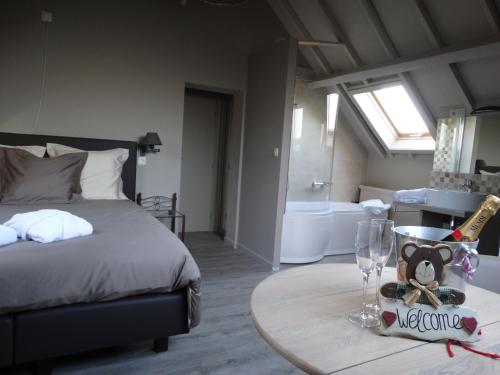 a bedroom with a bed and a table and a tub at B&B Castel 't Haantje in Ruiselede