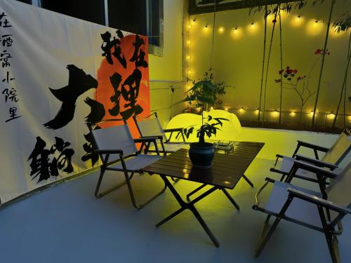 a table with chairs and a potted plant on it at 渔月撸猫客栈-大理古城店 in Dali