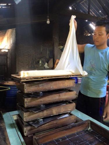 a man standing next to a table with a mattress at Griya Harja Homestay in Borobudur