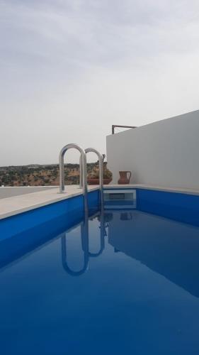 a blue swimming pool with two metal rails in it at Casa da Avó Dada in Torrão