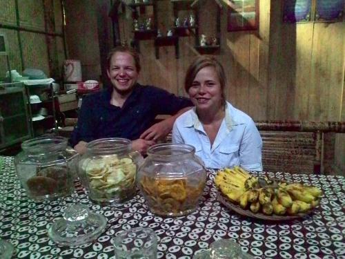 a man and woman sitting at a table with fruit at Griya Harja Homestay in Borobudur