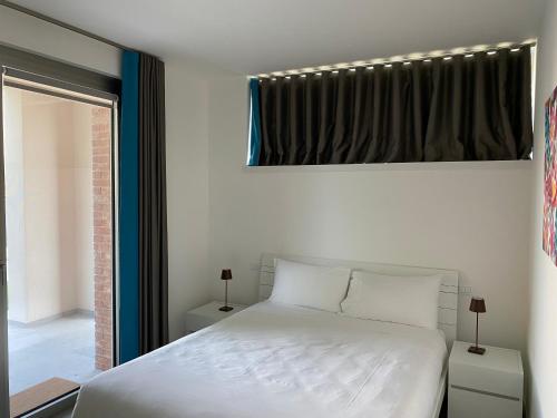 a bedroom with a white bed and a window at Sirmio Apartments - Darsena Stay in Sirmione