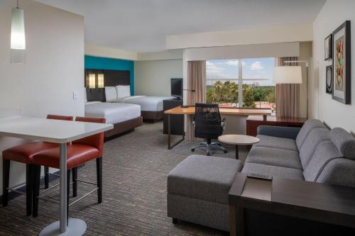 a hotel room with a couch and a bed at Residence Inn Orlando Convention Center in Orlando