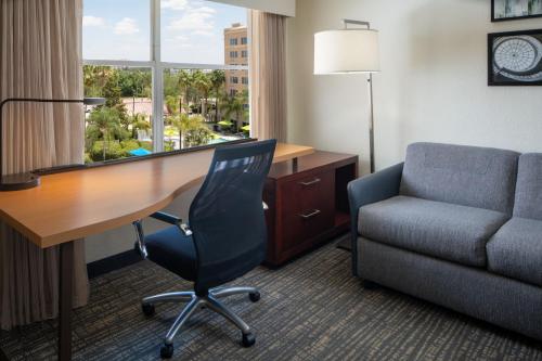 a hotel room with a desk and a chair and a window at Residence Inn Orlando Convention Center in Orlando