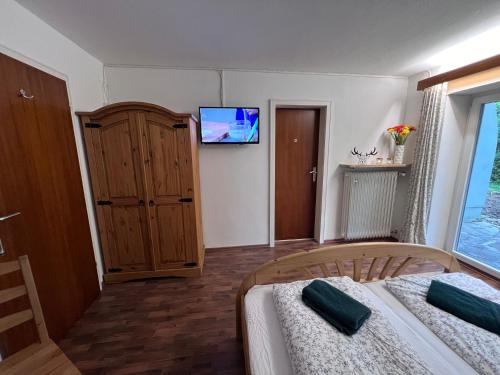 a bedroom with two beds and a tv on the wall at Der Erberbauer in Piding