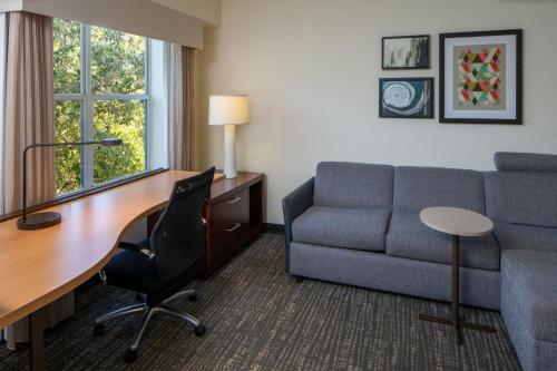 a hotel room with a couch and a desk and a chair at Residence Inn Orlando Convention Center in Orlando