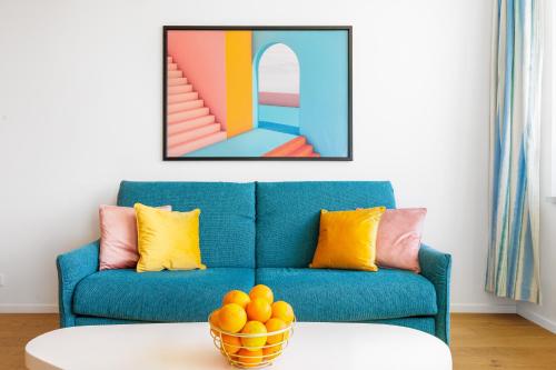 a blue couch in a living room with a bowl of oranges at SKY PARK 1 - Luxurious #INSTAworthy Apartment in Downtown City Center with Included Parking, Best Address in Town in Bratislava