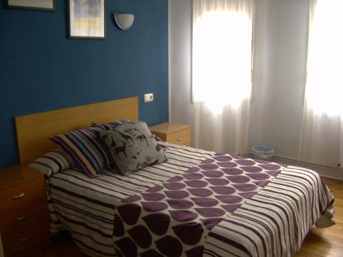 sypialnia z łóżkiem z niebieskimi ścianami i oknem w obiekcie Pensión Gema w mieście Irún