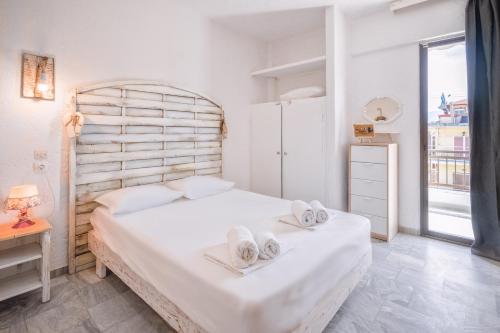 a bedroom with a large white bed and a window at Brunis Apartments in Nei Poroi
