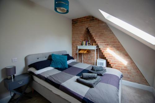 ein Schlafzimmer mit einem Bett mit Ziegelwand in der Unterkunft City View Apartment in Salisbury