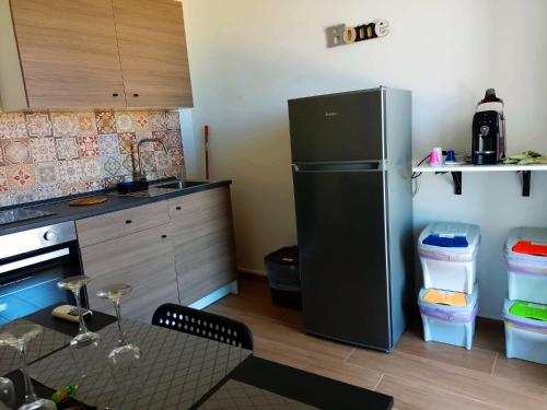 a kitchen with a black refrigerator and a table with a dining room at Granatelli Holiday Home in Altavilla Milicia