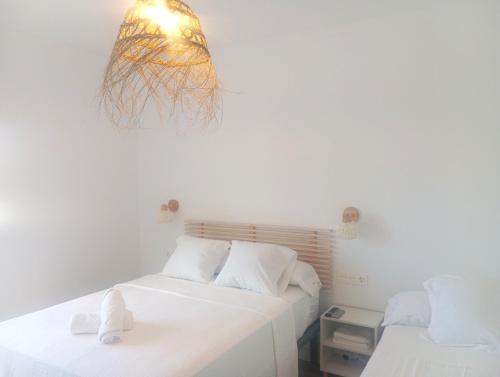 a bedroom with two beds and a light fixture at HOSTAL CASA EMILIO in Almería