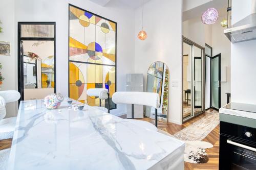 une salle à manger avec une table en verre et des miroirs dans l'établissement Appartement Luxueux et Fleuri à Toulouse, Capitole, à Toulouse