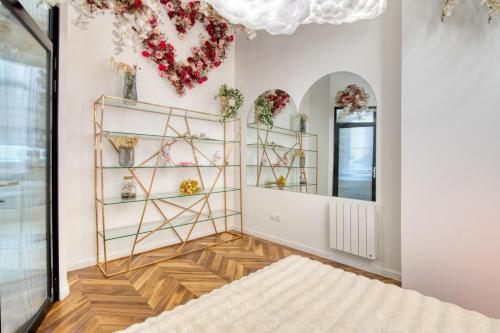 Cette chambre comprend des fleurs sur le mur et un miroir. dans l'établissement Appartement Luxueux et Fleuri à Toulouse, Capitole, à Toulouse