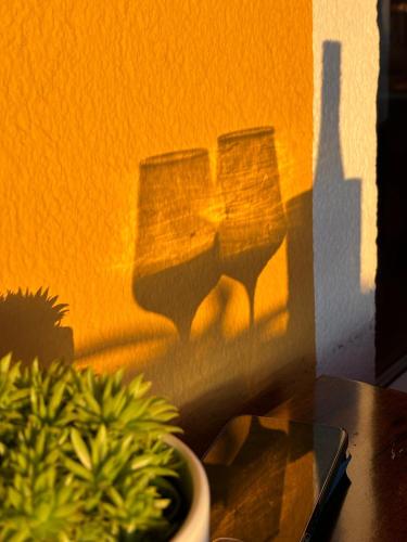 a shadow of three wine glasses on a wall at Panoramahotel Steirerland in Kitzeck im Sausal