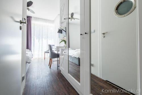 a room with a mirror and a bedroom with a table at Port 21 Pura Pool & Design Hotel - Adults Only in Krynica Morska