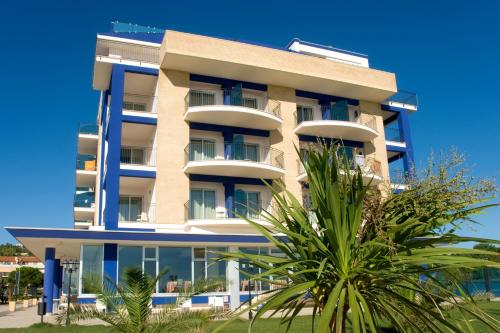 a building with a palm tree in front of it at Roses Hotel in Roseto degli Abruzzi