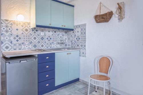 a kitchen with blue cabinets and a chair at Brunis Apartments in Nei Poroi