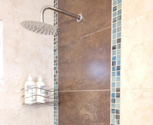 een douche met twee flessen water in een badkamer bij "Casa Amalia Apartamentos" Plaza Italia y Av Arístides a 50mts, lugar con jardín in Mendoza