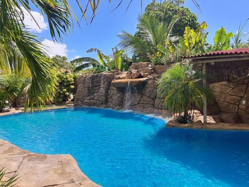 a swimming pool with a waterfall in a resort at Chalés Refúgio Fortim in Fortim