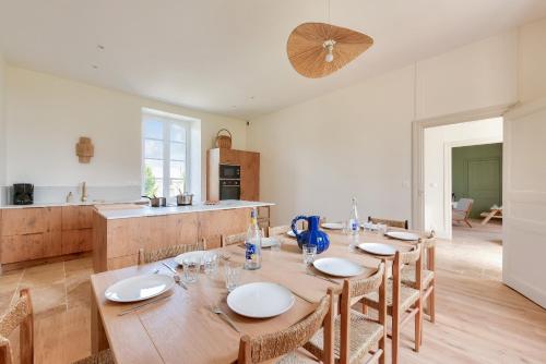 une salle à manger avec une table en bois et une cuisine dans l'établissement Maison familiale pour 12 adultes et 2 enfants, à Pléboulle