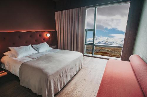 1 dormitorio con cama y ventana grande en Hótel Jökulsárlón - Glacier Lagoon Hotel, en Höfn