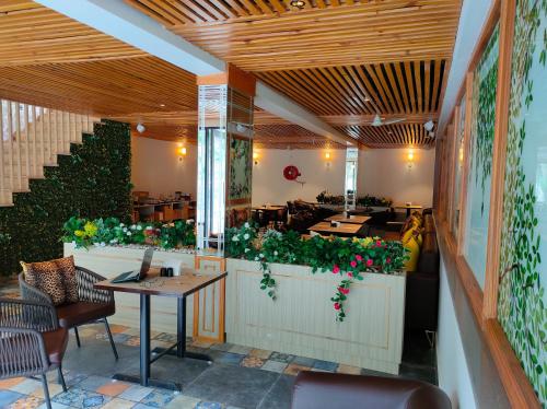 a restaurant with a table and chairs and plants at Hotel Rose Dale in Bhowāli