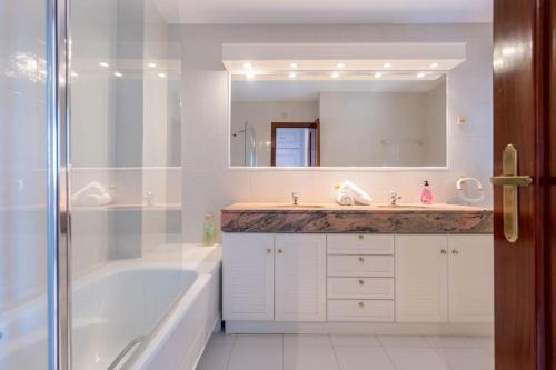 a bathroom with a tub and a sink and a mirror at Casa Nina junto Barcelona Centro y playa in Teià