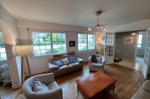 - un salon avec des canapés, une table et des fenêtres dans l'établissement Beautiful family house in Meucon, à Meucon