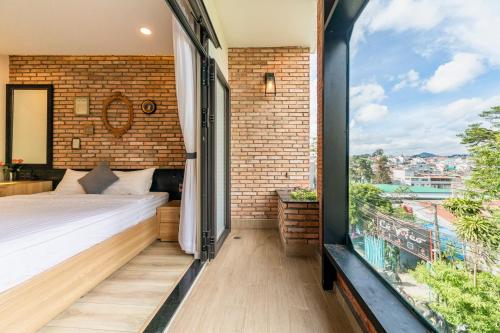 um quarto com uma cama e uma grande janela em The Brick Home dalat em Da Lat