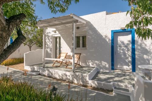 a white house with a blue door and a chair at Summer Residence in Provatas