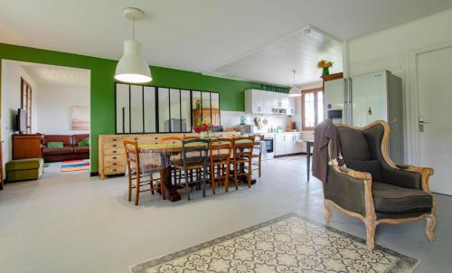 Una cocina y una sala de estar con mesa y sillas. en Le verger, en Rouilly-Sacey
