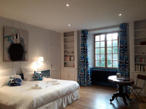 une chambre avec un lit, un bureau et une fenêtre dans l'établissement Manoir du Moustoir - Hôtel Les Empreintes, à Saint-Évarzec