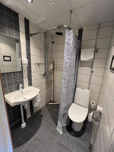 a bathroom with a sink and a toilet and a shower at Uppsala CityStay Hotel in Uppsala